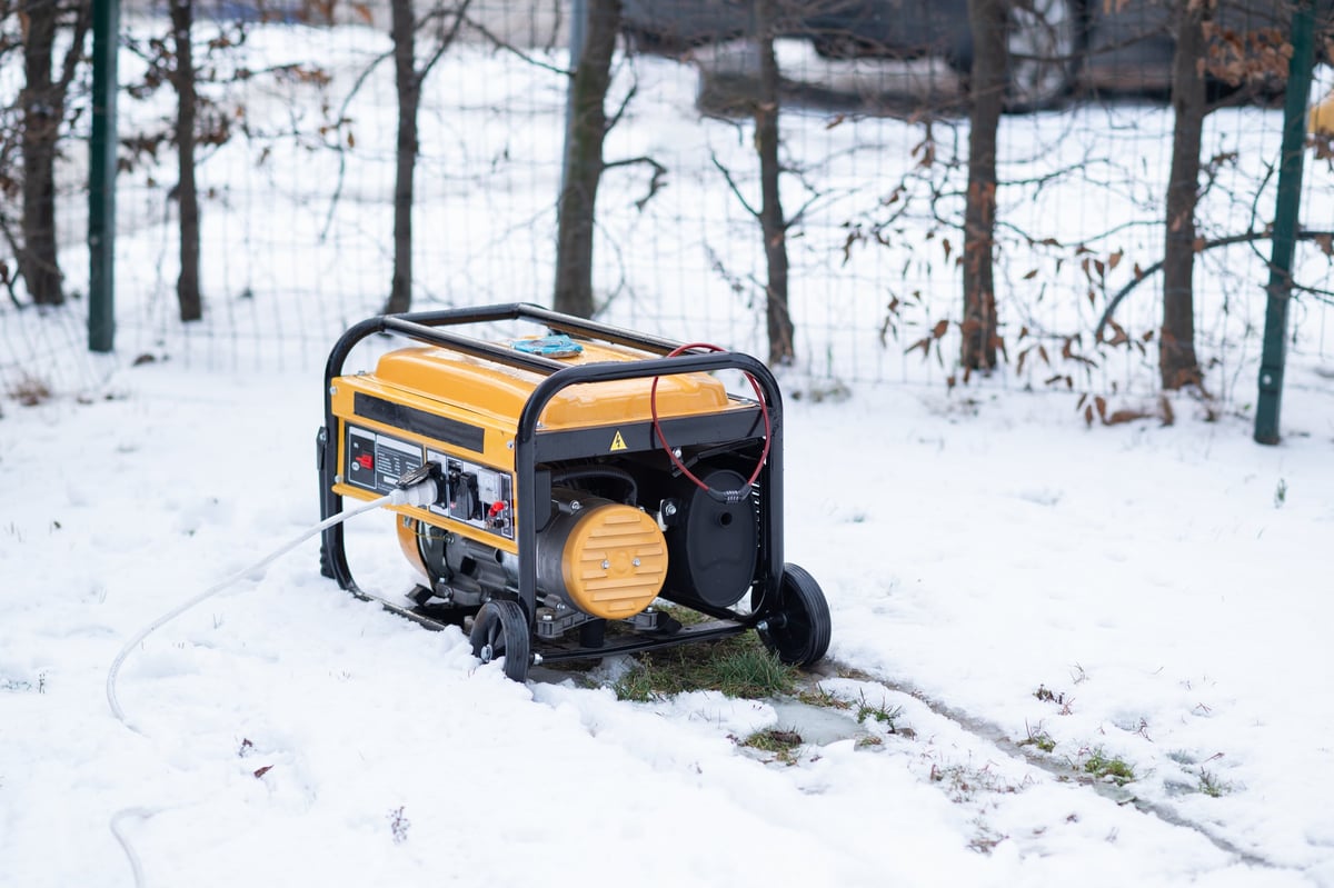 Yellow portable gasoline generator providing backup power in a snowy Pacific Northwest winter storm